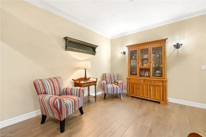 Sitting room featuring crown molding, baseboards, and light wood-type flooring