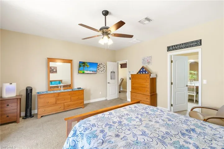 Bedroom with a ceiling fan, baseboards, visible vents, and carpet