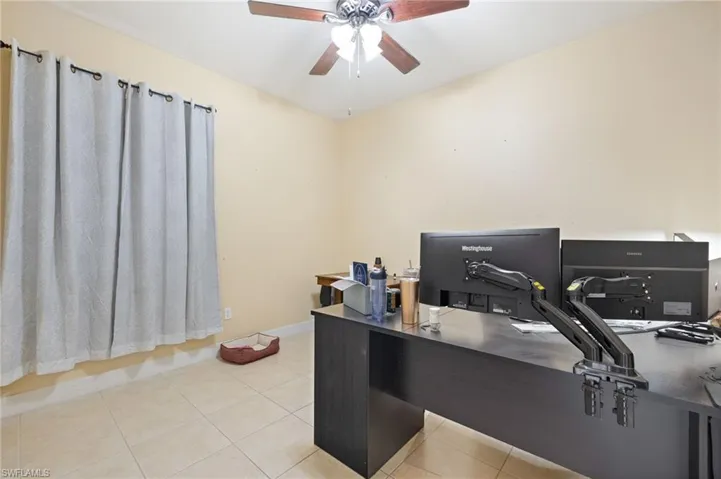 Bedroom used as an Office on the main floor featuring tile patterned floors, baseboards, and a ceiling fan