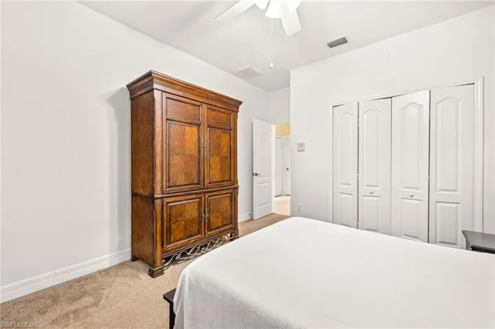 Bedroom featuring baseboards, light carpet, a closet, and visible vents
