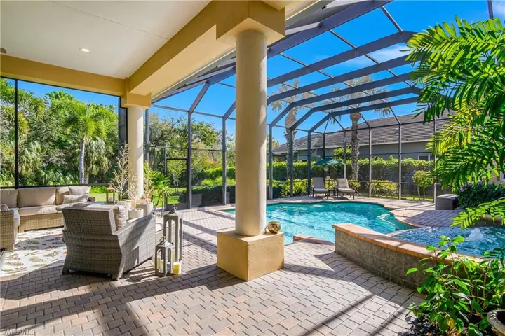 View of swimming pool featuring a lanai, patio surround, outdoor furniture, and a sunroom