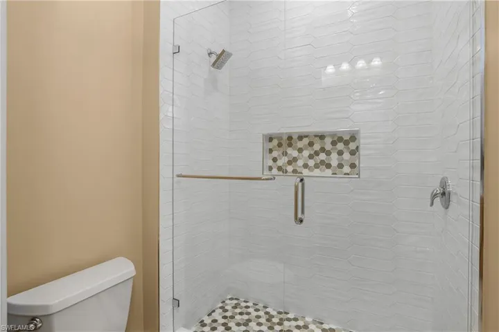 Bathroom with a stall shower and toilet