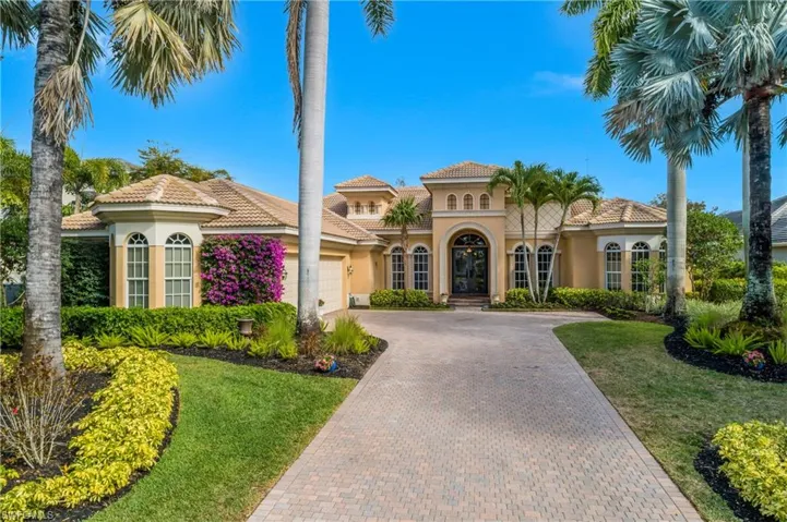 Mediterranean / spanish home with stucco siding, a tile roof, french doors, and decorative driveway