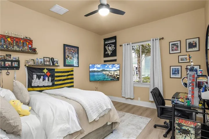 Bedroom featuring a desk, wood finished floors, and a ceiling fan