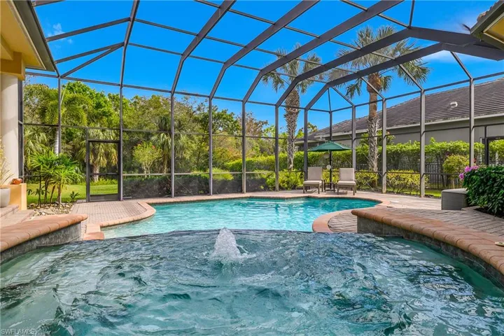 View of swimming pool featuring a sunroom, a lanai, and patio surround