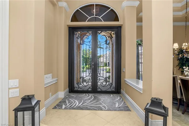 Entryway featuring a chandelier, crown molding, tile patterned flooring, and french doors