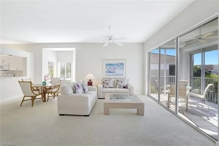 Carpeted living room with healthy amount of natural light and a ceiling fan
