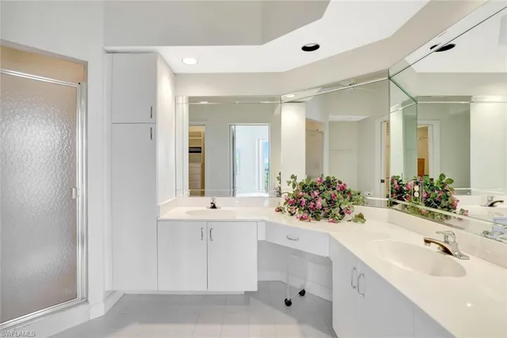Full bathroom with a stall shower, double vanity, light tile patterned flooring, and recessed lighting