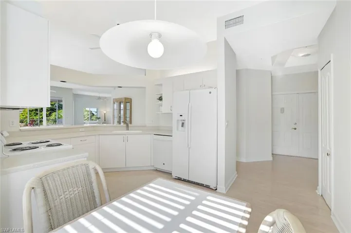 Kitchen with white appliances, white cabinetry, light countertops, open shelves, and ceiling fan
