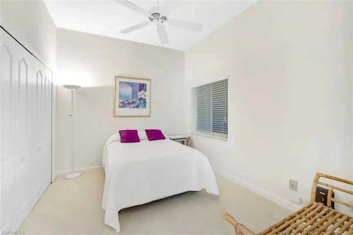 Carpeted bedroom with a ceiling fan and a closet