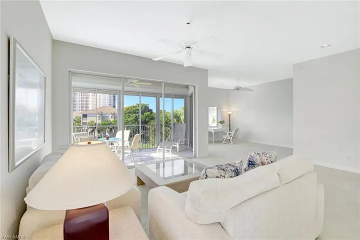 Carpeted living area featuring baseboards and a ceiling fan