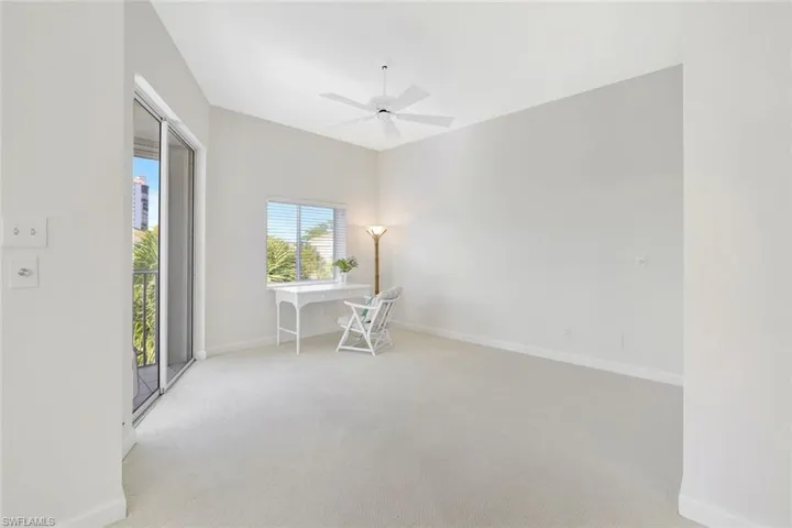 Office area featuring light carpet and a ceiling fan