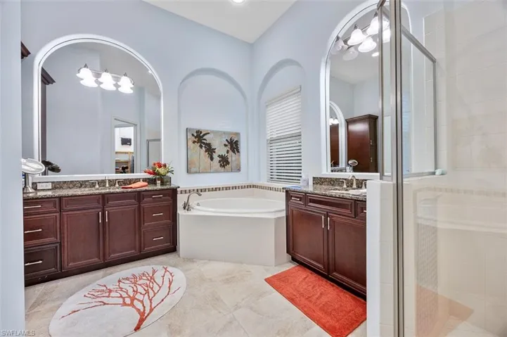 Bathroom with plus walk in shower, vanity, and tile patterned flooring