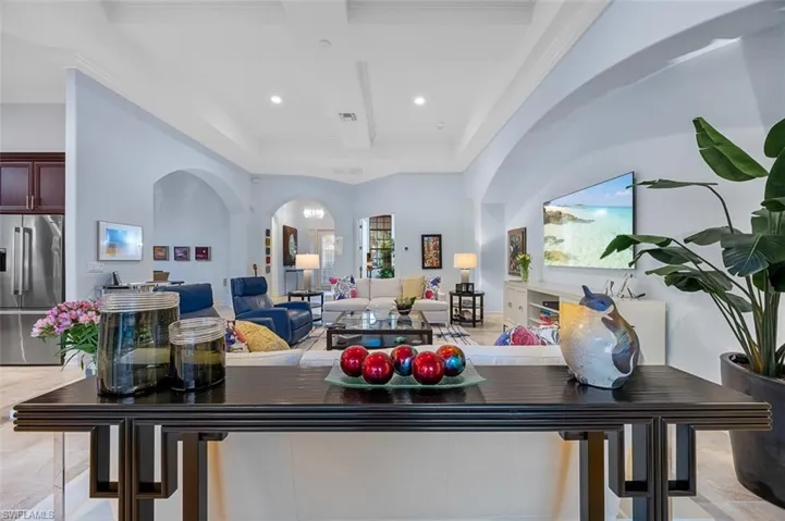 Living room with beamed ceiling, coffered ceiling, and ornamental molding