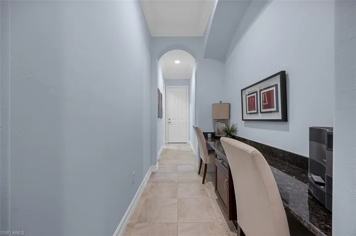 Hallway featuring crown molding and light tile patterned floors