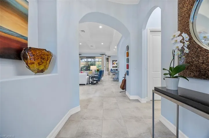 Corridor featuring coffered ceiling, beamed ceiling, and light tile patterned floors