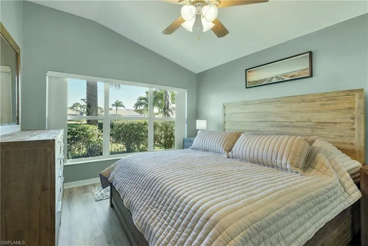 Bedroom featuring lofted ceiling, wood finished floors, and a ceiling fan