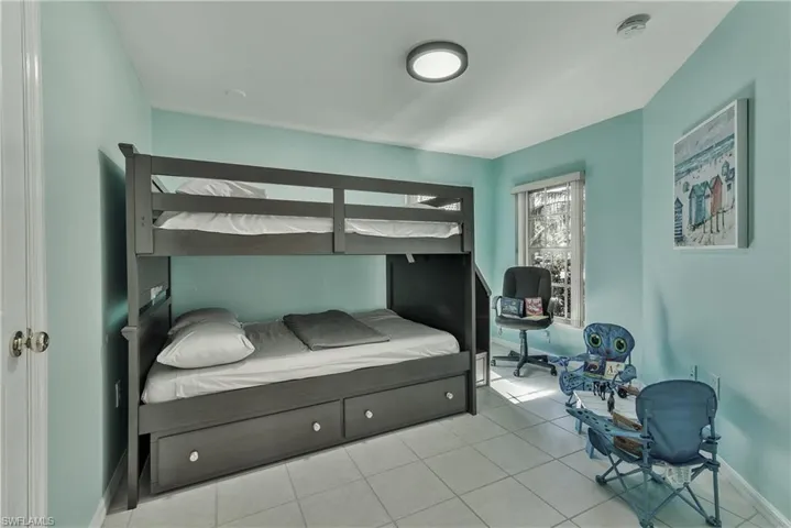 Bedroom with baseboards and light tile patterned flooring