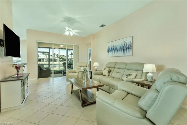 Living area featuring ceiling fan and light tile patterned floors