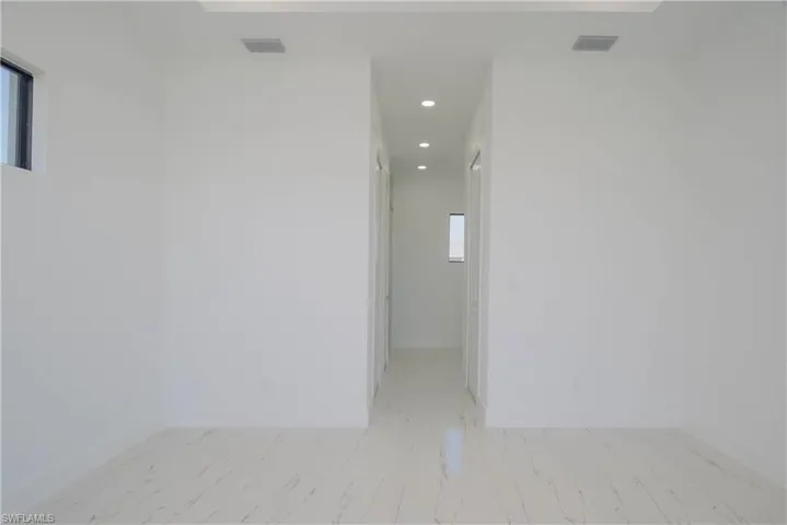 Empty room featuring recessed lighting, marble finish floor, visible vents, and baseboards