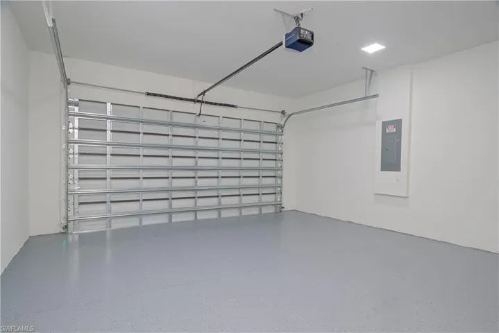 Garage featuring a garage door opener and electric panel