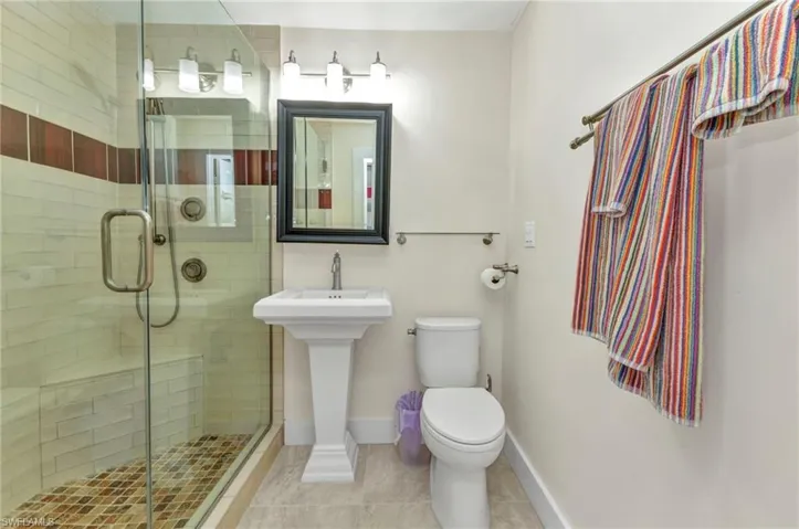 Bathroom with tile patterned floors and a shower stall
