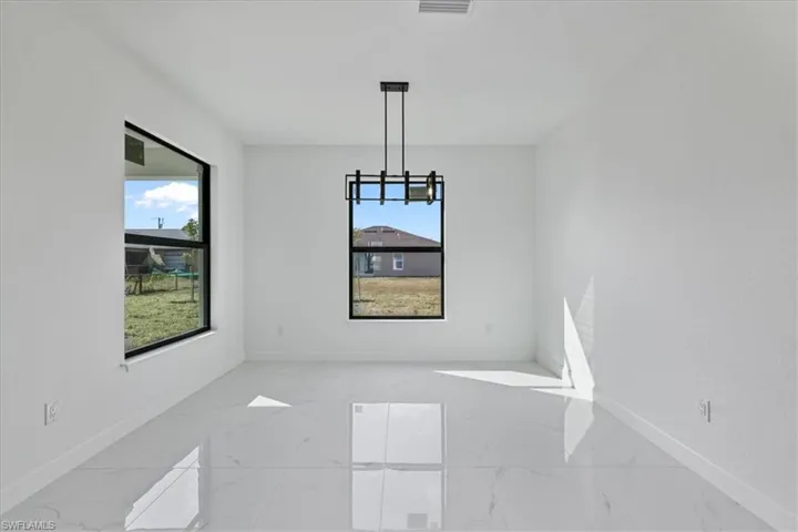 Unfurnished dining area with baseboards and light marble finish floors