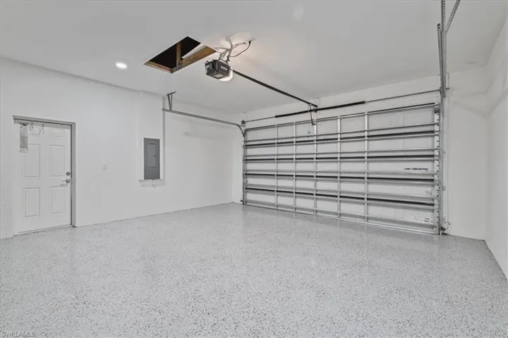 Garage with electric panel and a garage door opener