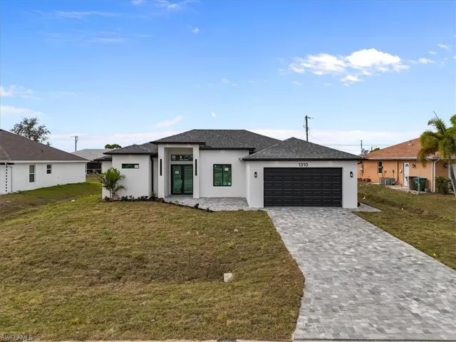 View of front of home featuring stucco siding, a front lawn, decorative driveway, an attached garage, and a shingled roof