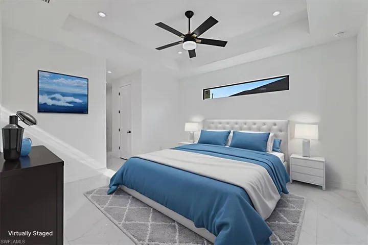 Bedroom featuring ceiling fan, a tray ceiling, and recessed lighting