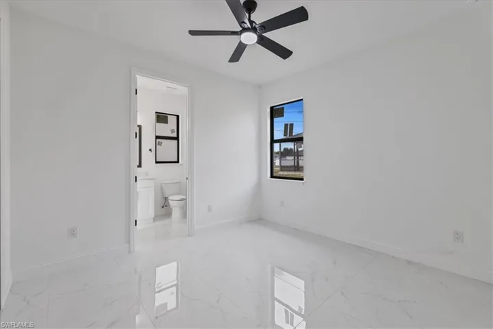 Spare room featuring a ceiling fan and light marble finish floors