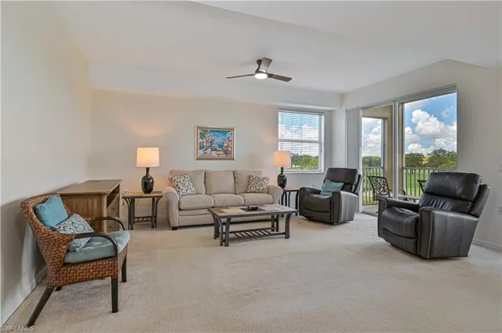 The living room is bright and airy, with plenty of natural light from the sliding glass door and big window.