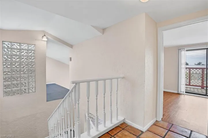 Corridor with a textured wall and an upstairs landing