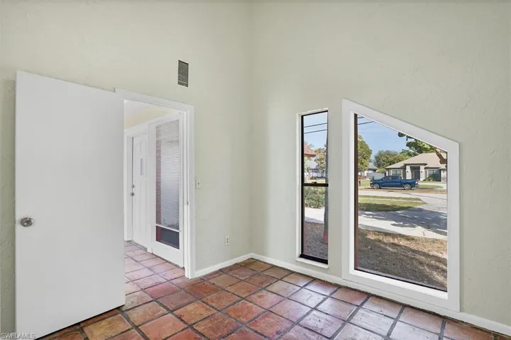 Den featuring a high ceiling and baseboards