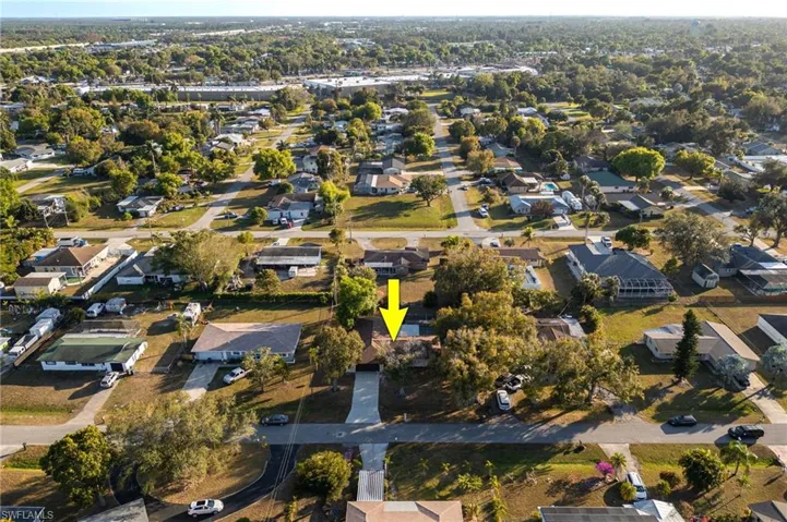 Aerial view of property and surrounding area featuring nearby suburban area