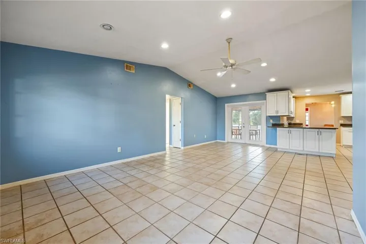 Unfurnished living room featuring french doors, a ceiling fan, recessed lighting, and light tile patterned flooring