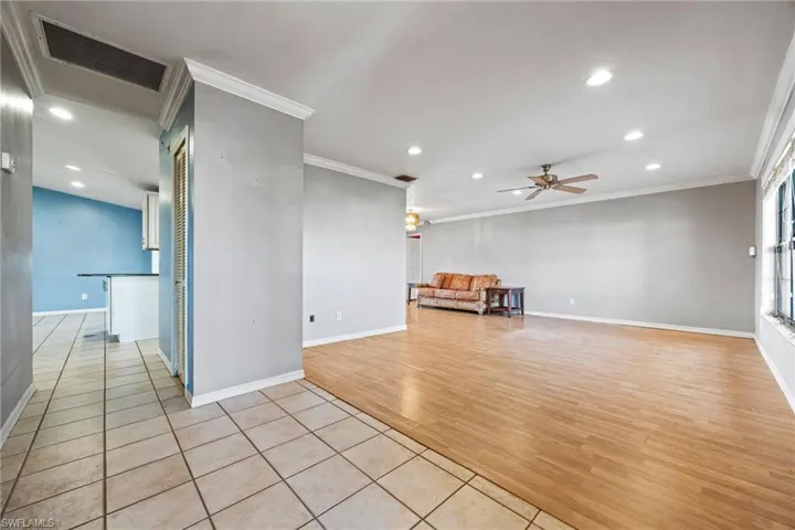 Unfurnished living room with light tile patterned flooring, recessed lighting, ornamental molding, and a ceiling fan