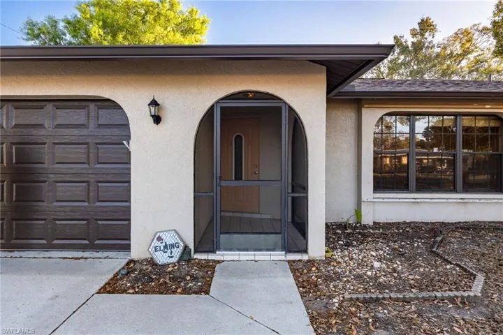 Entrance to property with stucco siding