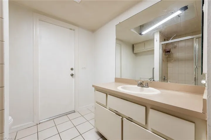 Bathroom with vanity, a stall shower, and light tile patterned floors
