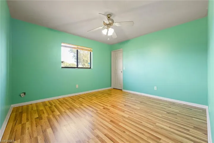Spare room with wood finished floors and ceiling fan