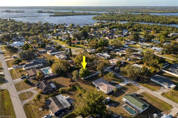 Aerial view of property and surrounding area with nearby suburban area and a nearby body of water