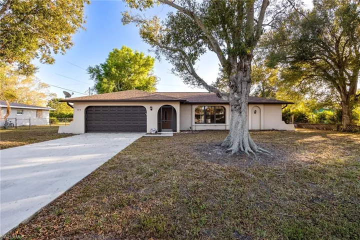 Ranch-style home featuring stucco siding, concrete driveway, and an attached garage