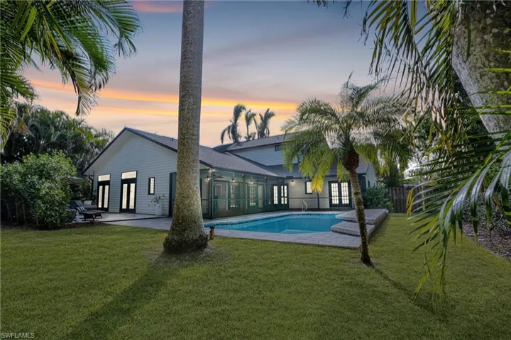 Rear view of house with french doors, a patio, and a shingled roof