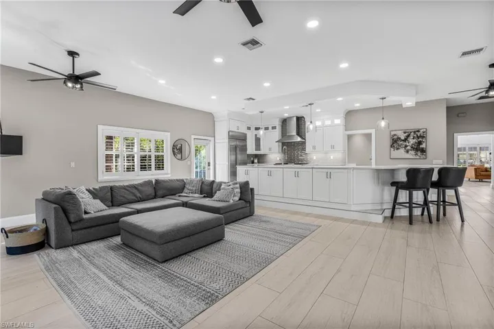 Kitchen featuring appliances with stainless steel finishes, white cabinetry, recessed lighting, light stone counters, and ceiling fan