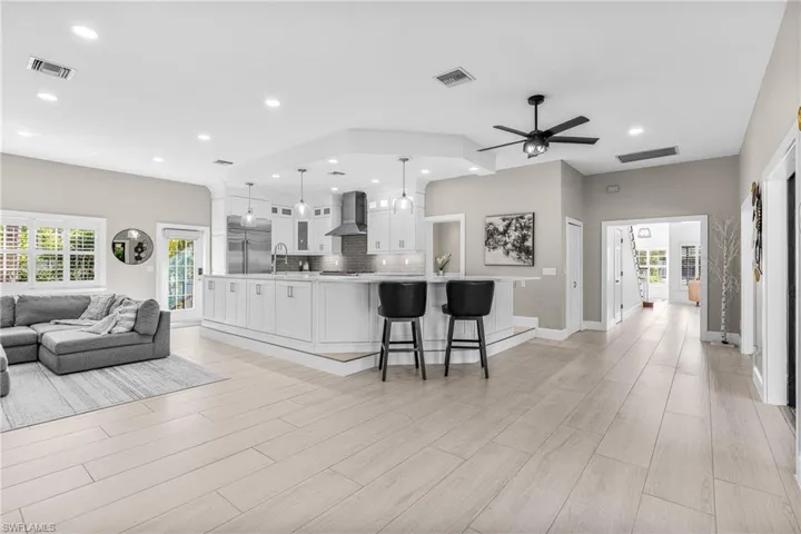 Living room with recessed lighting, stairway, and light wood-style flooring