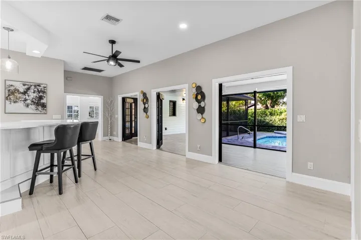 Living room with a ceiling fan, a fireplace, recessed lighting, and light wood-type flooring