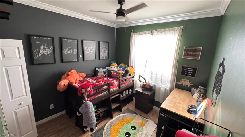 Bedroom featuring ornamental molding, a ceiling fan, and wood finished floors