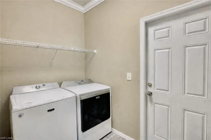Laundry room featuring washing machine and dryer and crown molding