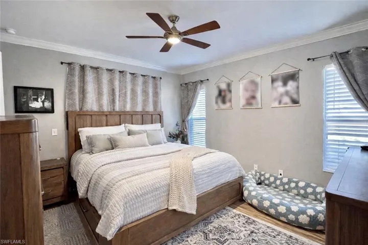 Bedroom featuring crown molding, ceiling fan, and wood finished floors