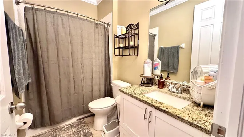 Full bath with vanity, crown molding, and a shower with curtain